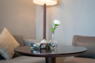 a vase with a white flower on a table at ALiving Stylish Studio with Partial Burj & Canal Views- Prive , Business bay 713 in Dubai
