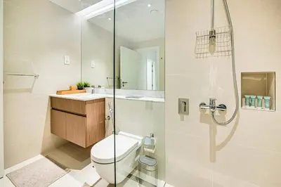a bathroom with a toilet and a glass shower at Amazing 1BD sea view apartment in Port de La Mer in Dubai