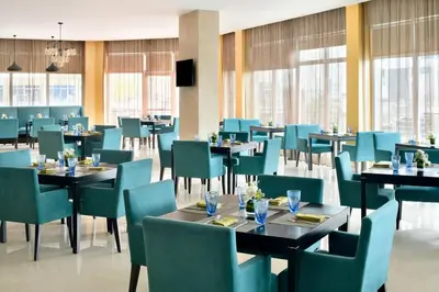 a dining room with tables and chairs and windows at ModernLux - Luxury Duplex 1 BR in Movenpick Hotel JLT with Lake View in Dubai