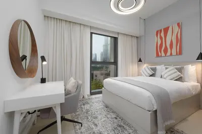 a bedroom with a bed and a desk and a mirror at Maison Privee - Luxury 2Bedroom with Burj Khalifa & Fountain Views in Dubai