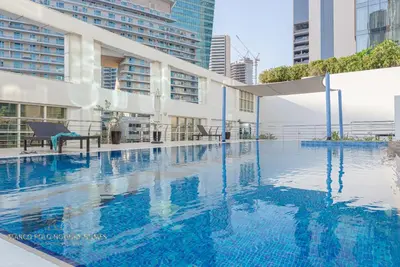 an empty swimming pool in a building with tall buildings at Marco Polo - Enjoy comfort and class near Burj Khalifa in Dubai