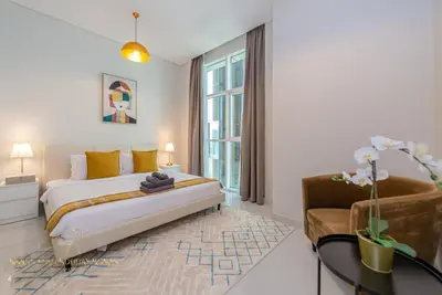 a bedroom with a bed and a table and a chair at Marco Polo - Enjoy comfort and class near Burj Khalifa in Dubai