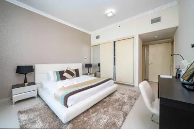 a bedroom with a large white bed and a desk at Beachfront 1 Bed with Full JBR View in Dubai