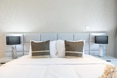 a large bed with two lamps on two tables at 3BDR Apartment with Maid Room and Burj Khalifa View in Dubai