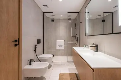 a bathroom with a sink and a toilet and a mirror at 3BDR Apartment with Maid Room and Burj Khalifa View in Dubai