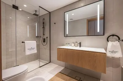 a bathroom with a sink and a toilet and a mirror at 3BDR Apartment with Maid Room and Burj Khalifa View in Dubai
