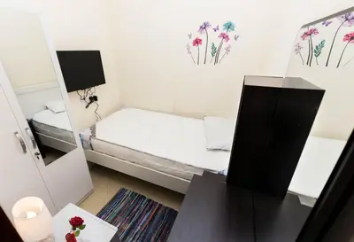 a small room with a bed and a mirror at Roomy Dubai Hostel Small Rooms and Partitions at Marina in Dubai