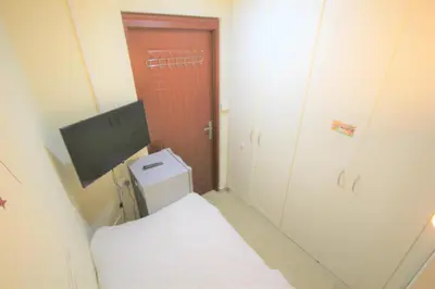 a small bathroom with a toilet and a television at Roomy Dubai Hostel Small Rooms and Partitions at Marina in Dubai