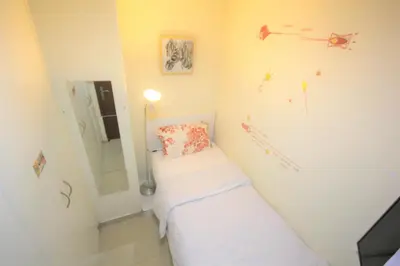 a small room with a bed and a mirror at Roomy Dubai Hostel Small Rooms and Partitions at Marina in Dubai