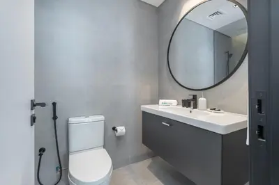a bathroom with a toilet and a sink and a mirror at Contemporary Ranch Living with Burj Khalifa View in Dubai