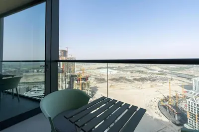 a bench in a room with a view of a city at Modern 1bdr - 10min from Burj Khalifa - Sobha Waves in Dubai
