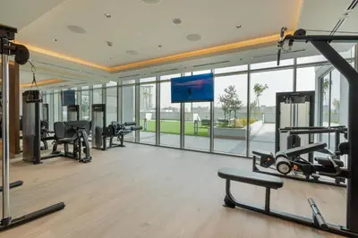 a gym with cardio equipment and a large window at Modern 1bdr - 10min from Burj Khalifa - Sobha Waves in Dubai