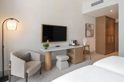 a hotel room with a desk with a tv and a chair at Vida Creek Beach Hotel in Dubai