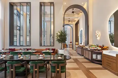 a restaurant with tables and chairs and windows at Vida Creek Beach Hotel in Dubai