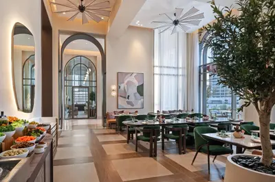 a restaurant with tables and chairs and large windows at Vida Creek Beach Hotel in Dubai