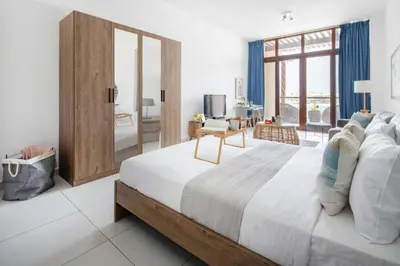 a bedroom with a large bed with a large window at Frank Porter - Palm Views East in Dubai