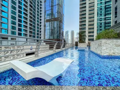 a swimming pool on a building with tall buildings at The Smart Concierge - Princess tower in Dubai