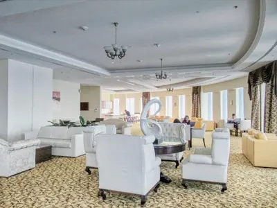 a salon with white chairs and a table and a room at The Smart Concierge - Princess tower in Dubai