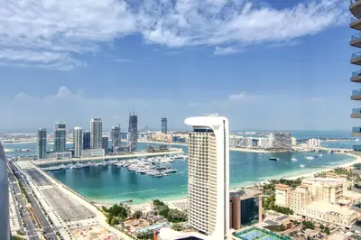a view of a city with a harbor and a tall building at The Smart Concierge - Princess tower in Dubai