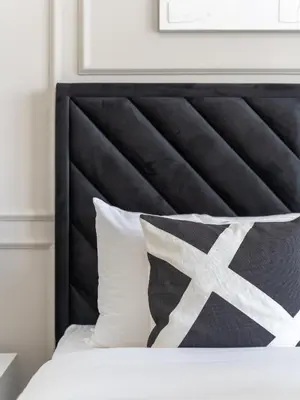 a bed with a black headboard and white pillows at Exceptional 2BR-Private Beach Access-Palm Jumeirah in Dubai