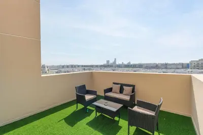 a balcony with chairs and a couch and a table at Central 1bdr - Al Quoz - Al Khail Height in Dubai