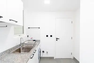 a white kitchen with a sink and white cabinets at Central 1bdr - Al Quoz - Al Khail Height in Dubai