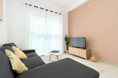 a living room with a couch and a tv at Central 1bdr - Al Quoz - Al Khail Height in Dubai