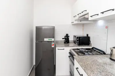 a kitchen with a stainless steel refrigerator and a stove at Central 1bdr - Al Quoz - Al Khail Height in Dubai