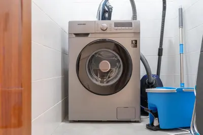a washing machine in a bathroom with a bucket at Dunya Tower Luxury and 2 min walk to Dubai Mall and Burj Khalifa in heart of Downtown in Dubai