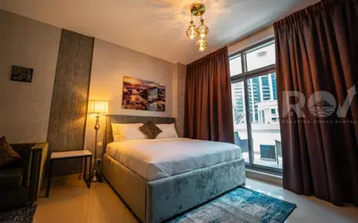 a bedroom with a bed and a large window at Studio with Boulevard View in Dubai
