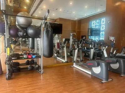 a gym with several tread machines and a television at Studio with Boulevard View in Dubai