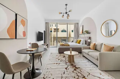a living room with a couch and a table at Silkhaus new studio in JVC with queen Bed in Dubai