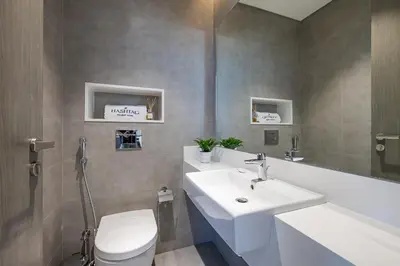 a bathroom with a white sink and a toilet at Fully Furnished I Lagoons View I District One in Dubai