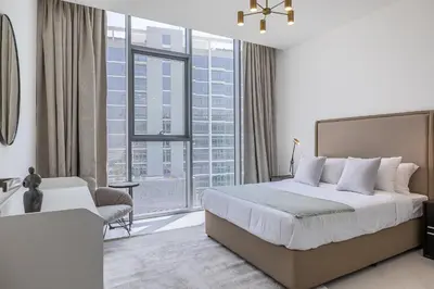 a bedroom with a bed and a large window at Fully Furnished I Lagoons View I District One in Dubai