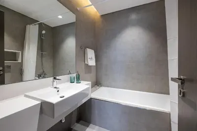a bathroom with a sink and a bath tub at Fully Furnished I Lagoons View I District One in Dubai