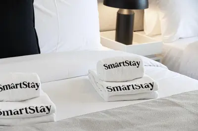 a pile of towels sitting on top of a bed at SmartStay at Burj Royale - Full Burj Khalifa View - Brand New Luxury Apartments in Dubai