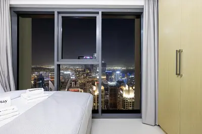 a bedroom with a window with a view of a city at SmartStay at Burj Royale - Full Burj Khalifa View - Brand New Luxury Apartments in Dubai