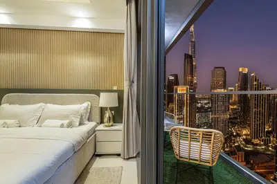 a bedroom with a bed and a view of a city at Luxe 2BR with Burj Khalifa View & Infinity Pool in Dubai