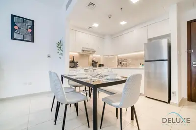 a kitchen with a table and chairs and a refrigerator at Soothing 1BR at Safi 1B Town Square Dubailand by Deluxe Holiday Homes in Dubai