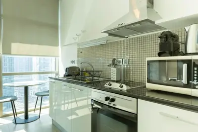 a kitchen with a microwave and a counter top at Nasma Luxury Stays - White Haven Studio With Charming Cityscape Views in Dubai