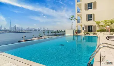 a swimming pool in a building with a view of the water at Luxurious 4BR Penthouse with Assistant Room and a Sweeping Balcony Showcasing Burj Khalifa and Sea Views, Le Pont, La Mer by Deluxe Holiday Homes in Dubai
