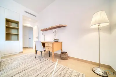 a room with a desk and a lamp at Luxurious 4BR Penthouse with Assistant Room and a Sweeping Balcony Showcasing Burj Khalifa and Sea Views, Le Pont, La Mer by Deluxe Holiday Homes in Dubai