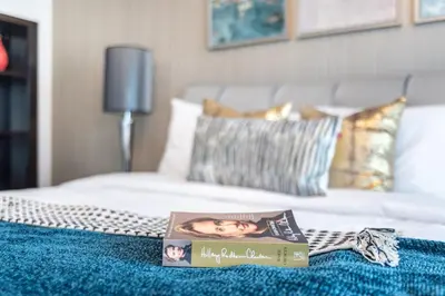 a book sitting on top of a bed at Luxury 2BR Apartment with Stunning Burj Khalifa & Fountain Views - Opera Grand, Downtown in Dubai