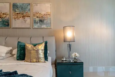 a bedroom with a bed and a lamp on a night stand at Luxury 2BR Apartment with Stunning Burj Khalifa & Fountain Views - Opera Grand, Downtown in Dubai