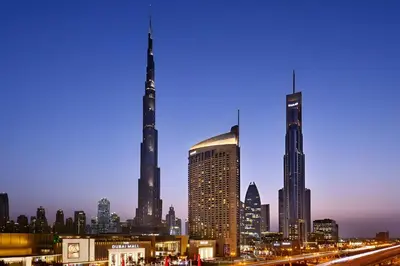 a city skyline at night with two tall buildings at Fashion avenue Dubai Mall -The Residence in Dubai