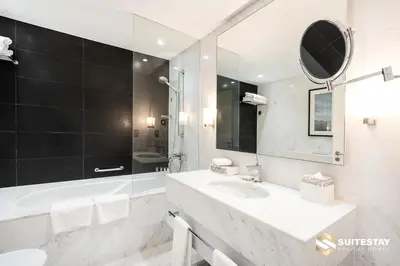 a white bathroom with a sink and a mirror at Fashion avenue Dubai Mall -The Residence in Dubai