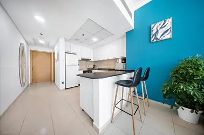 a kitchen with white and blue walls and stools at 1Br Suit with Full Canal View - Down Town in Dubai