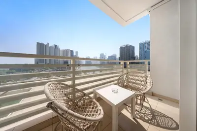 two chairs and a table on a balcony with a city skyline at 1Br Suit with Full Canal View - Down Town in Dubai