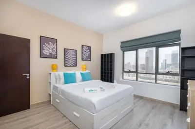 a bedroom with a large bed and a large window at Hidden Gem 1 Bedroom apt in Dubai Sport City in Dubai