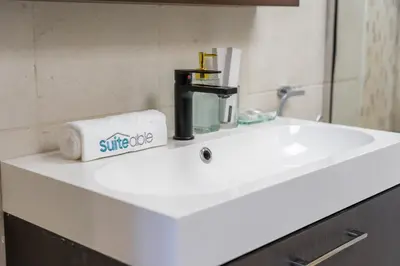 a white sink in a bathroom with a towel at Hidden Gem 1 Bedroom apt in Dubai Sport City in Dubai